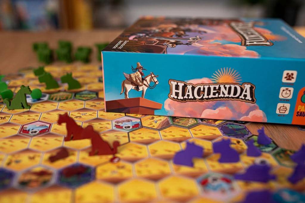 The box for the board game Hacienda placed above the game board