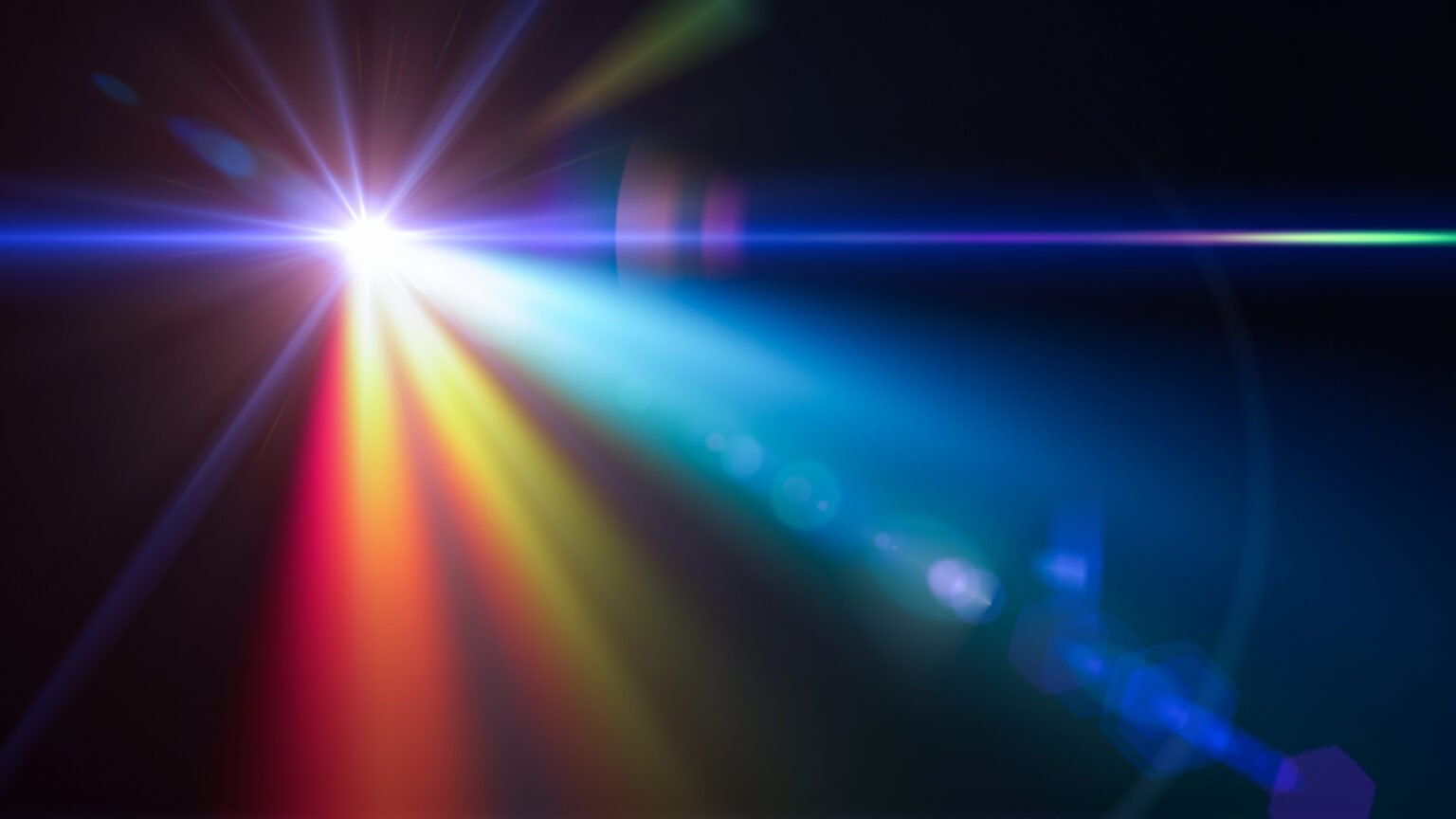 a single bright, white source of light against a black background, with lens flare and a prism effect creating a complex mix of different colored light rays.