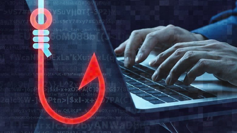 Rendered graphic of a fishing hook overlayed on a close-up of hands typing on a laptop keyboard.