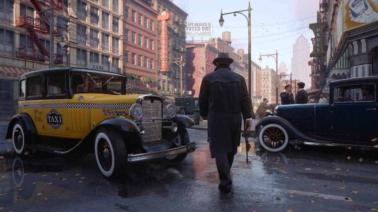 Tommy walking through the streets near a taxi while holding a tommy gun in Mafia Definitive Edition.