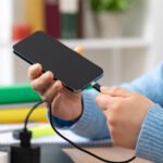 No, using your phone while it charges won't wreck the battery