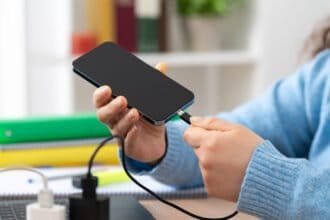 No, using your phone while it charges won't wreck the battery