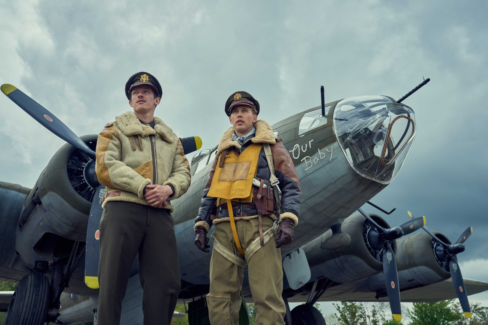 Callum Turner and Austin Butler stand befor Our Baby, one of the many il-fated Fortresses that co-star in Masters of the Air. It’s bristling with guns.
