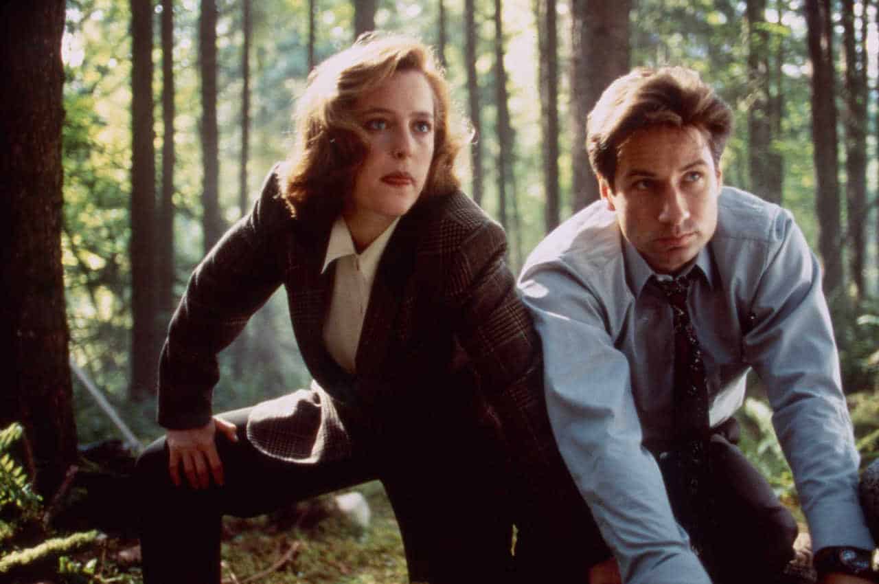 Mulder and Scully squatting in the woods in The X-Files