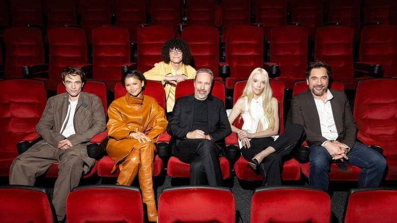 The cast of Dune: Part 3 sits together in a bright, red chaired theater.