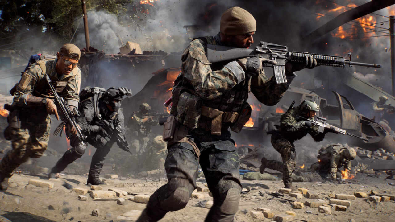 A squad of soldiers move past a crashed helicopter.